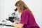 Young laboratory assistant looking through a microscope