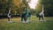 Young ladies in sports clothing are exercising in park doing yoga on mats on green and yellow grass. Healthy lifestyle