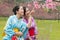 Young ladies standing beside the cherry tree