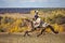 Young lady in 19th century dress riding a akhal teke horse