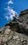 Young lady alpinist climbing mountain under blue sky.