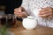 Young lady brewing tea add teaspoon of sugar to cup