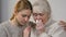 Young lady comforting unhappy crying granny suffering loss, support in family