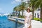 Young lady in dress and hat walking near the marina jetty