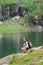 Young lady hiker with backpack sitting on mountain