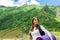 Young lady hiker with backpack sitting on mountain