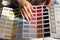 Young lady illustrator hold palette of colored samples in hands