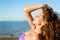 Young lady with long curly hair enjoying on the beach