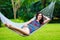 Young lady with long dark hair relaxing in hammock on the tropic