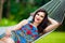 Young lady with long dark hair relaxing in hammock on the tropic