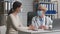 Young lady patient and woman practitioner wearing protective medical face masks talking at clinic office, slow motion