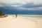 Young lady photographer in bikini walks on the caribbean tropical island sandy beach, Cuba vacation