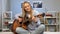 Young lady playing guitar in her room, writing song, dreaming of music career