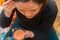 Young lady putting on her make up looking on a pocket mirror