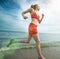 Young lady running at the sunny summer sand beach. Workout. Jog