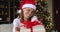 Young lady in Santa hat offer you New Year gift