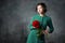 Young lady standing with a peony flower in hands