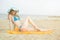 Young lady sunbathing on a beach. Beautiful woman posing at the