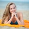 Young lady sunbathing on a beach. Beautiful woman posing at the