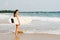 Young lady surfer standing on the beach with surf board