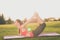 Young lady trainer is making stretching lying outdoors in spring