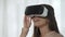 Young lady using futuristic VR technology and laughing, pleased with imagery