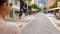 Young lady walking along street with shops, looking for sales, European city