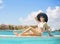 Young lady in white bikini relaxing in luxury resort