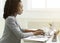 Young Lady Working On Laptop Sitting At Workplace, Side View