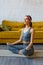 A young Latin American woman does yoga at home. Athletically built young woman stretches out in the living room of a beautiful