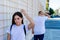 Young Latin couple arguing in the street. The woman in the foreground with the man behind. Concept of fight, heartbreak, stress,