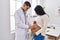 Young latin couple doctor and patient auscultating baby at clinic