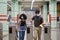 Young latin couple wearing protective face mask walking through subway turnstile at the train or metro station