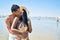 Young latin couple wearing swimwear hugging and kissing at the beach