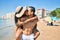 Young latin couple wearing swimwear  walking and kissing at the beach