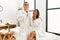 Young latin couple wearing towel standing at beauty center bored yawning tired covering mouth with hand