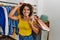 Young latin customer woman smiling happy holding shopping bags at clothing store