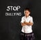 Young latin cute schoolgirl scared and sad and the words stop bullying text written with chalk