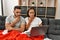 Young latin ill couple having medical teleconsultation using laptop at home