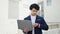 Young latin man business worker using laptop looking clock at street