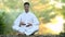 Young latin man sitting on the wall and meditating