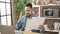 Young latin man using laptop reading document looking upset at dinning room