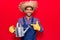Young latin man wearing farmer hat and gloves holding watering can smiling happy pointing with hand and finger