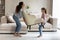 Young Latin mom and teen daughter decorate home