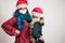 Young latin mother and daughter looking to the camera with tinsel sparkled and protective mask celebrating new normal christmas