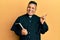 Young latin priest man holding bible smiling happy pointing with hand and finger to the side