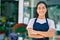 Young latin shopkeeper girl with arms crossed smiling happy standing at the florist