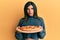 Young latin transsexual transgender woman holding italian pizza depressed and worry for distress, crying angry and afraid