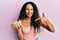 Young latin woman holding chickpeas bowl smiling happy pointing with hand and finger