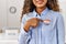 Young latin woman smiling confident pointing with finger to i voted badge at electoral college